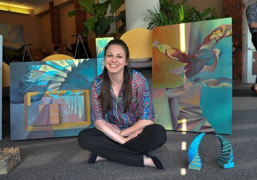 Student in front of their artwork